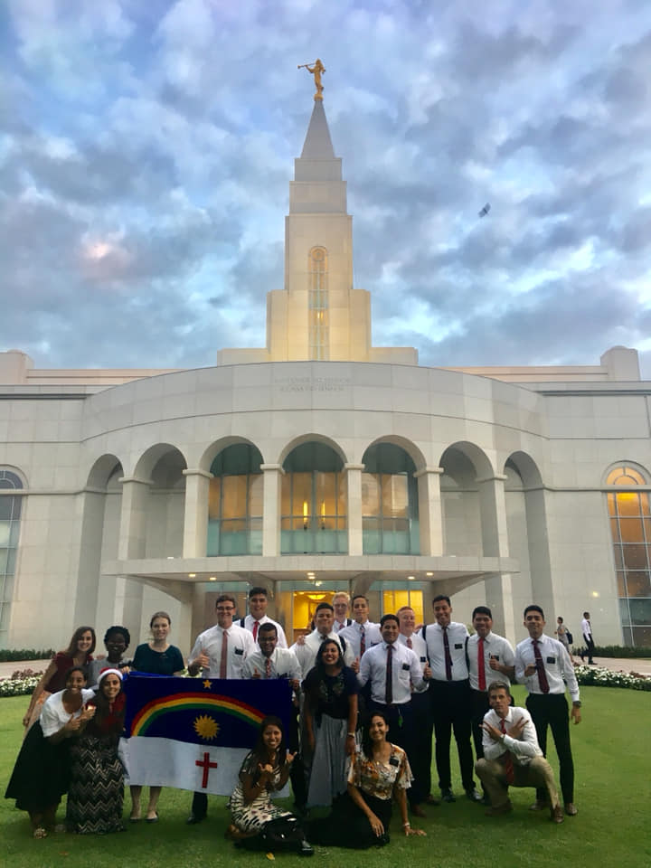 Latter-day Saint missionaries with the flag of Pernambuco in front of the Recife temple