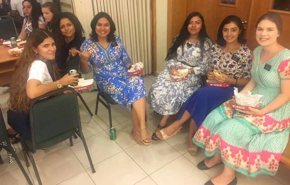 A group of sister missionaries eating together at zone conference.