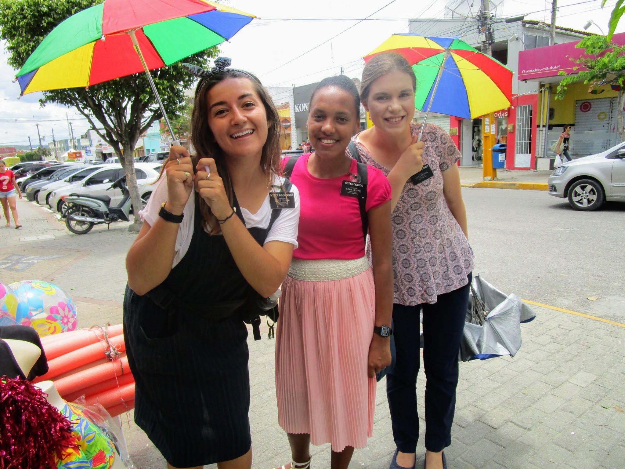 Sister Broadbent, Sister Centeio, and Sister Faulconer, Missionaries for the Church of Jesus Christ of Latter-day Saints holding small frevo umbrellas in Brazil